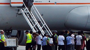 A group of asylum seekers get  on board an airplane at Cocos (AAP Image/ Brad Waugh)