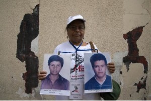 Clementina Murcia González, from Honduras, holds up the pictures of her two missing sons, Jorge Orlando Funes Murcia and Mauro Orlando Funes